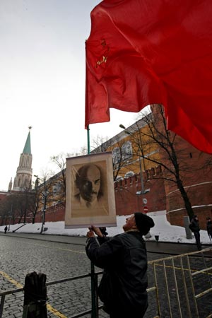 An old Russian Communist Party member places a flag with a picture of Lenin in Red Square in Moscow, capital of Russia, on Jan. 21, 2009. Hundreds of representatives of the Russian Communist Party placed wreaths to Lenin's Mausoleum Wednesday, marking the 85th anniversary of the death of Vladimir Lenin - the founder of the Soviet state.