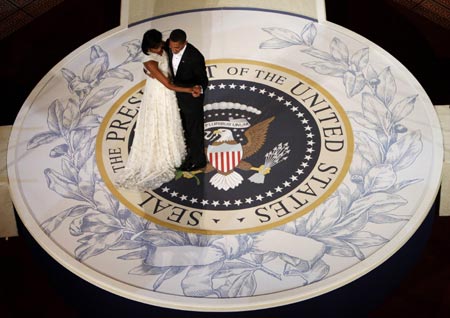 First lady Michelle Obama and President Barack Obama dance on a replica of the presidential seal at the Commander-in-Chiefs Inaugural ball in Washington January 20, 2009. Obama took power as the first black U.S. president on Tuesday and quickly turned the page on the Bush years, urging Americans to rally to end the worst economic crisis in generations and repair the U.S. image abroad.