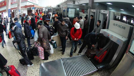 Passengers go through security check at the entrance of the Changsha Railway Station in Changsha, capital of central-south China's Hunan Province, Jan. 21, 2009. With the approach of the Chinese lunar New Year, Hunan railways have transported over 1 million passengers since the formal start of the annual Spring Festival travel peak on Jan. 11. 