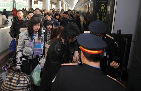 Passengers queue to get on a train at the Railway station in Lanzhou, capital of north China's Gansu Province, Jan. 21, 2009. With the approach of the Chinese lunar New Year, Lanzhou railway station is confronted with the mushroom of passenger flow. 