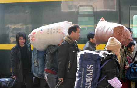 Passengers queue to get on a train at the Railway station in Lanzhou, capital of north China's Gansu Province, Jan. 21, 2009. With the approach of the Chinese lunar New Year, Lanzhou railway station is confronted with the mushroom of passenger flow. 