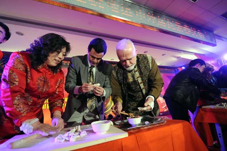 Chinese and foreign residents make Jiaozi during a celebration for the Chinese lunar New Year in a community in the Chaoyang District of Beijing, capital of China, Jan. 20, 2009. 