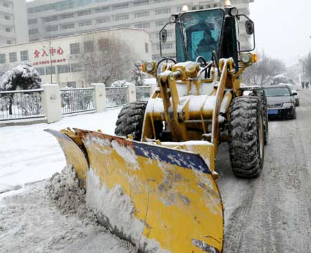 A bulldozer cleans snow in Shenyang, capital of northeast China's Liaoning Province, Jan. 22, 2009. An overnight snow hit Shenyang for the first time in 2009.