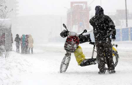 A motorcyclist stands in snow in Shenyang, capital of northeast China's Liaoning Province, Jan. 22, 2009. (Xinhua Photo)