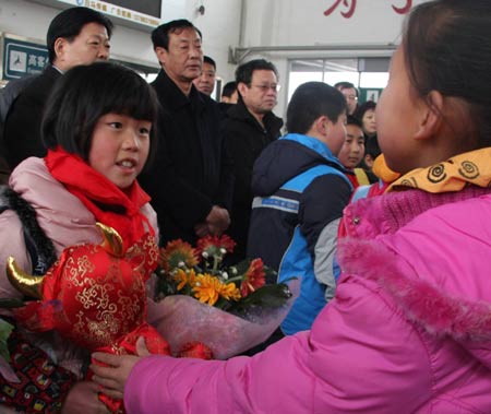  A girl from quake-affected Sichuan Province (L) receives a gift from her peer of 'love family' at the railway station in Cangzhou, north China