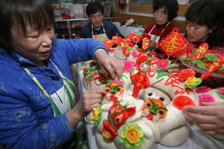 Workers make huamo, a kind of steamed bread eaten during festivals, at a workshop in Yuncheng, north China's Shanxi Province, Jan. 21, 2009. As the Spring Festival, or Chinese lunar New Year, draws near, huamo becomes popular here. 