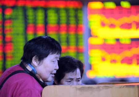 Investors watch the share prices at a stock exchange in Chongqing, southwest China Jan. 23, 2009. 