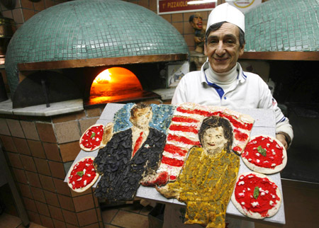 Pizza chef Gaetano Esposito displays his creation, a pizza in the form of U.S. President Barack Obama and his wife Michelle, in front of his brick ovens in Naples Jan. 22, 2009. 