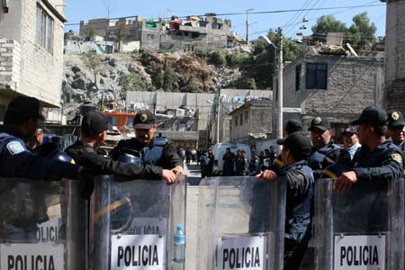 Policemen stand near the scene of a landslide in Mexico City, capital of Mexico, Jan. 22, 2009.