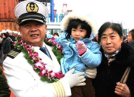 Peng Weiyuan, captain of the Chinese cargo ship Zhenhua 4 pose with his family members during a commendation ceremony at Changxing Island Port in Shanghai, east China, Jan. 23, 2009.