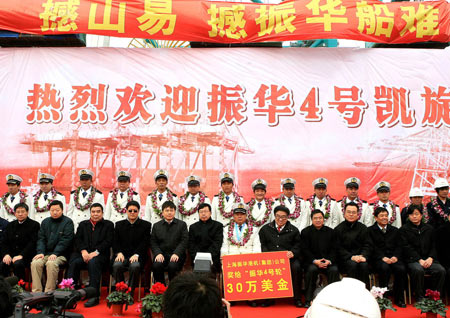 The crew members of the Chinese cargo ship Zhenhua 4 and guests pose for cameras during a commendation ceremony at Changxing Island Port in Shanghai, east China, Jan. 23, 2009. 