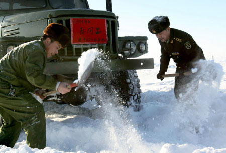 Soldiers clear the way for a military truck after heavy snowfall, Habahe County, Northwest China's Xinjiang Uygur Autonomous Region, January 22, 2009. [Xinhua] 