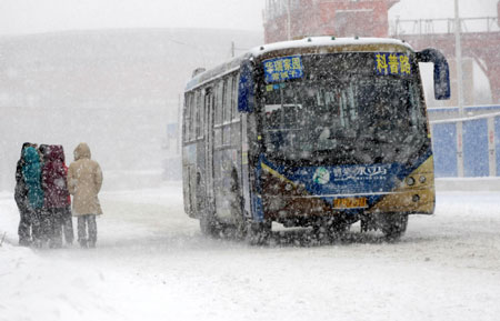 A bus drives on a snow-covered road in Shenyang City, North China's Liaoning Province, January 22, 2009. [Xinhua]