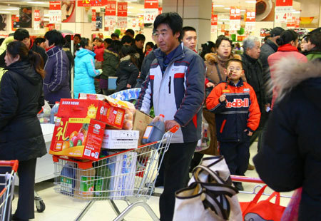 A local resident shop for 'festival necessities' for the upcoming Chinese Lunar New Year at a supermarket in Beijing, January 23, 2009. [Xinhua] 