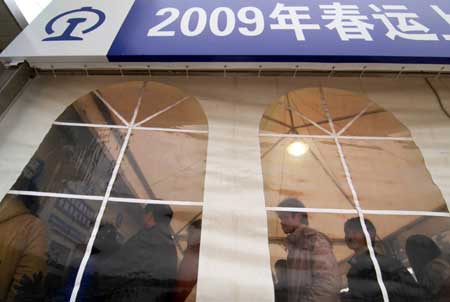 People buy tickets in a temporarily wind- sheltering ticket house in Shanghai, east China, Jan. 23, 2009. The cold wave is moving south across much of China, causing inconvenience for people struggling to get home for Chinese Lunar New Year. [Photo: Xinhua]