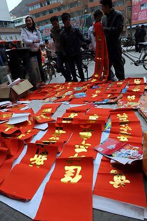 Locals select Spring Festival couplets at Kangxian County in Longnan, a quake-hit city of northwest China's Gansu Province, Jan. 25, 2009. Quake zone residents in west China had made their own ways to welcome the Spring Festival, or the Chinese Lunar New Year. [Xinhua]