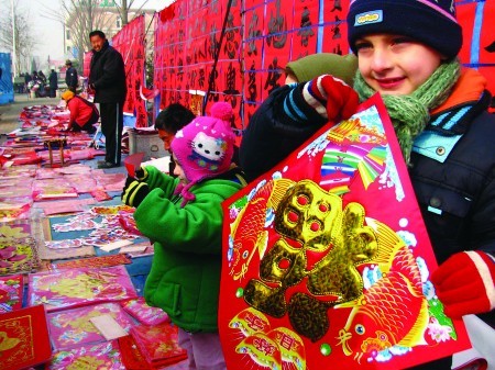 British tourists do Spring Festival shopping in a market in Qingdao, east China's Shandong Province, on January 19, 2009. With red lanterns hanging from the eaves, the bangs of firecrackers outside, and tables of delicious food, people in China observed the Lunar New Year eve in the traditional way.