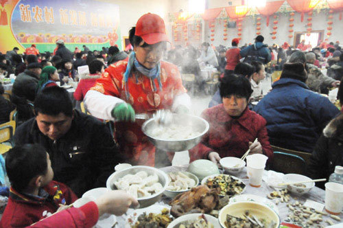 A village leader serves dumplings at a party in Liuminying village in suburban Beijing on Sunday, January 25, 2009, the Lunar calendar's New Year's Eve. More than 1,000 villagers attended the dumpling-party, which has been running for nearly 30 years and in which the whole village eats dumplings together to celebrate the New Year. [Photo: Xinhua]