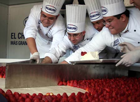 Chefs cut a giant cheesecake that broke Guinness World Record for the biggest cheesecake of the world in Mexico City, capital of Mexico, Jan. 25, 2009. The cheese cake, with 2.5 meters in diameter, 55 centimeters in height and 2 tons in weight, was made by 55 chefs and 5 student chefs and cost 800 kilograms of cheese.