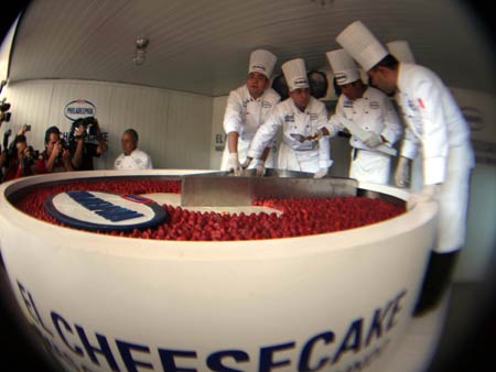 Chefs cut a giant cheesecake that broke Guinness World Record for the biggest cheesecake of the world in Mexico City, capital of Mexico, Jan. 25, 2009. The cheese cake, with 2.5 meters in diameter, 55 centimeters in height and 2 tons in weight, was made by 55 chefs and 5 student chefs and cost 800 kilograms of cheese.