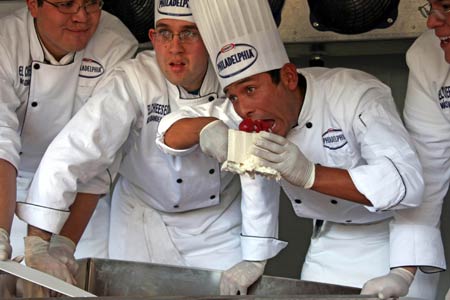 A chef tastes a piece of a giant cheesecake that broke Guinness World Record for the biggest cheesecake of the world in Mexico City, capital of Mexico, Jan. 25, 2009. The cheese cake, with 2.5 meters in diameter, 55 centimeters in height and 2 tons in weight, was made by 55 chefs and 5 student chefs and cost 800 kilograms of cheese.