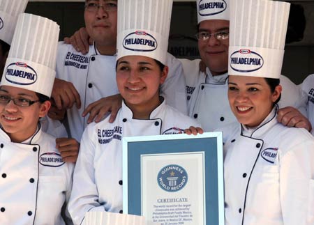 Student chefs display a certificate of Guinness World Record for the biggest cheesecake of the world in Mexico City, capital of Mexico, Jan. 25, 2009. The cheese cake, with 2.5 meters in diameter, 55 centimeters in height and 2 tons in weight, was made by 55 chefs and 5 student chefs and cost 800 kilograms of cheese.