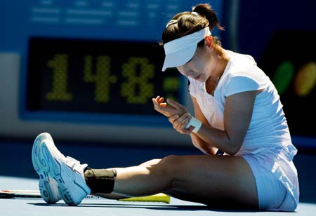 Zheng Jie of China checks her left wrist during women's singles match against Svetlana Kuznetsova of Russia at the Australian Open tennis tournament in Melbourne, Jan. 26, 2009. Svetlana Kuznetsova of Russia entered the quarter-finals after China's Zheng Jie retired injured from their fourth round match.