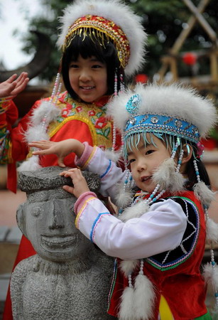 Children wearing minority costumes pose for photographs in celebration of the Chinese Lunar New Year in the city of Kunming, southwest China's Yunnan province Monday January 26, 2009. Spring Festival, or the Chinese Lunar New Year, is the most important traditional Chinese festival that calls for family reunion. It falls on Jan. 26 this year.[Xinhua]