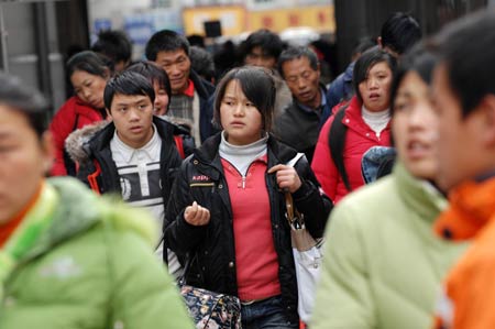 Migrant workers walk out of Hangzhou Railway Station in Hangzhou, east China&apos;s Zhejiang Province, Jan. 30, 2009. As the Spring Festival holiday is about to finish, passenger transportation of the Spring Festival started to reach the peak of return passengers. 