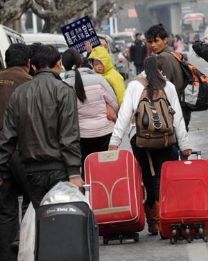 Migrant workers walk out of Hangzhou Railway Station in Hangzhou, east China&apos;s Zhejiang Province, Jan. 30, 2009. As the Spring Festival holiday is about to finish, passenger transportation of the Spring Festival started to reach the peak of return passengers. 