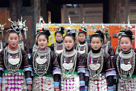 A squad of festively-costumed maidens sing their ethnic Dong's Ka Lau chorus, the big song of their distinguished folk vocal art, to entertain visitors across the country to admire this notable intangible cultural heritage, at the Gaozeng Township, Congjiang County, southwest China's Guizhou Province, Jan. 29, 2009.