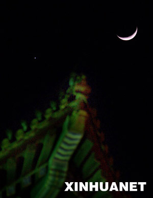 A crescent moon (R) is seen with the planet Venus in the sky over Beijing, Jan. 30, 2009. Venus and the moon appear close together, presenting a beautiful scene for people during the Chinese Lunar New Year. This phenomenon will last 3 days from Jan.30,2009, astronomer said.