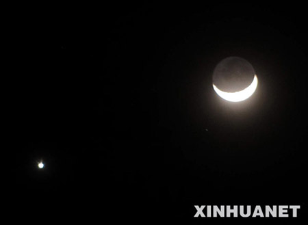 A crescent moon (R) is seen with the planet Venus in the sky over central China&apos;s Xiangxiang city,Jan. 30, 2009.