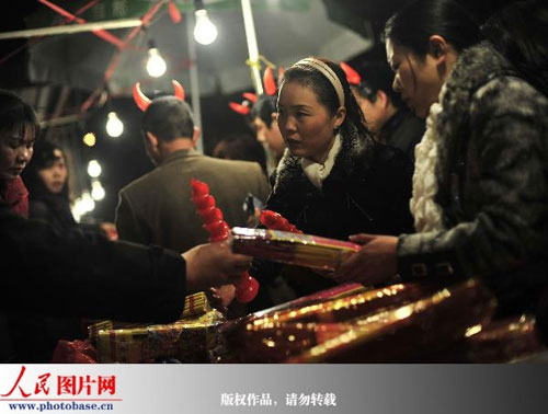 Pilgrims choose packages of incense in Guiyuan Temple. The temple, which has a decade-long history concerning the worship of God of Fortune, recorded an inflow of 300,000 pilgrims in the depth of night on Friday. [Photo: photobase.cn]