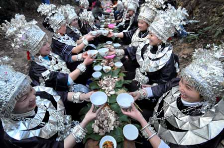 Women of Miao ethnic group toast at a dinner in the Zhanliu Village of Jianhe County, southwest China's Guizhou Province, Jan. 31, 2009. [Xinhua]