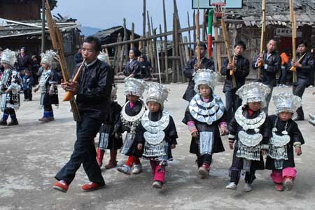 Children dressed in the costume of Miao ethnic group perform dance in the Zhanliu Village of Jianhe County, southwest China's Guizhou Province, Jan. 31, 2009. [Xinhua] 