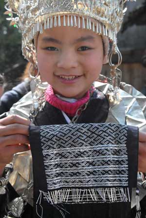 A girl of Miao ethnic group shows her embroidery in the Zhanliu Village of Jianhe County, southwest China's Guizhou Province, Jan. 31, 2009. [Xinhua] 