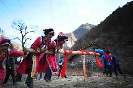 A man of the Qiang ethnic group cooks in Qugu township of Maoxian County, southwest China's Sichuan Province, Jan. 30, 2009. 