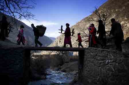 People of the Qiang ethnic group bring goods to home after activities held in Qugu township of Maoxian County, southwest China's Sichuan Province, Jan. 30, 2009. 