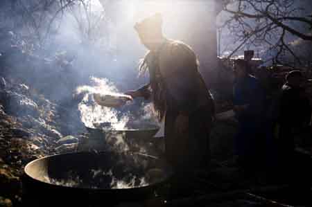 A man of the Qiang ethnic group cooks in Qugu township of Maoxian County, southwest China's Sichuan Province, Jan. 30, 2009. 