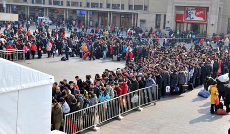 Passengers wait for security check at the entrance of the Beijing Railway Station in Beijing, capital of China, Jan. 31, 2009. The peak of return passenger transportation occured here at the end of the Spring Festival holidays.