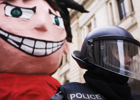 A riot policeman stands in front of a giant mascot confiscated during a demonstration against the ongoing Davos World Economic Forum, in Geneva January 31, 2009. 
