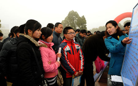 A working staff introduces job information to jobseekers during a job fair held in Lu'an, east China's Anhui Province, on Saturday, Jan. 31, 2009. There were lots of job fairs held, providing job opportunities to migrant workers at the end of the Spring Festival holidays, in different places of Anhui Province, one of the main source of migrant workers in China. [Photo: Xinhua]