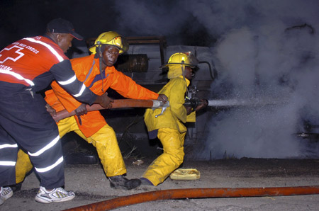 Firefighters attempt to extinguish a fire at the site of an oil spill blaze, after an oil truck crashed, near the central Rift Valley town of Molo Jan. 31, 2009.(Xinhua/Reuters Photo)