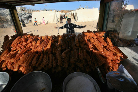 A boy stands by a cart selling sweets at a camp of Palestinians who lost their homes during the 22-day Israeli offensive in Jabalia, northern Gaza Strip, Jan. 31, 2009.(Xinhua/Wissam Nassar)