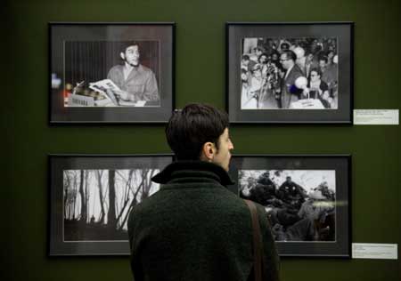 A visitor looks at photos during a photo exhibition marking the 50th anniversary of Cuban revolution, in Moscow, Russia, Feb. 1, 2009. The exhibition was held especially for the visiting Cuban leader Raul Castro. 