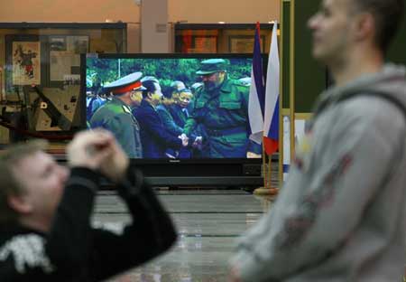 Visitors look at photos during a photo exhibition marking the 50th anniversary of Cuban revolution, in Moscow, Russia, Feb. 1, 2009. 