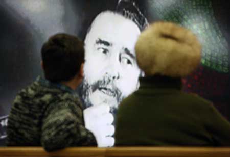 Visitors look at a photo during a photo exhibition marking the 50th anniversary of Cuban revolution, in Moscow, Russia, Feb. 1, 2009. 