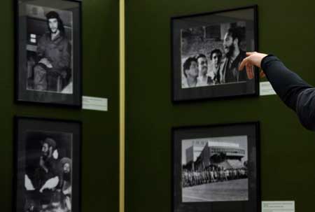 A visitor points to a photo during a photo exhibition marking the 50th anniversary of Cuban revolution, in Moscow, Russia, Feb. 1, 2009. The exhibition was held especially for the visiting Cuban leader Raul Castro.