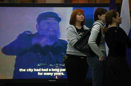 Visitors look at photos during a photo exhibition marking the 50th anniversary of Cuban revolution, in Moscow, Russia, Feb. 1, 2009.